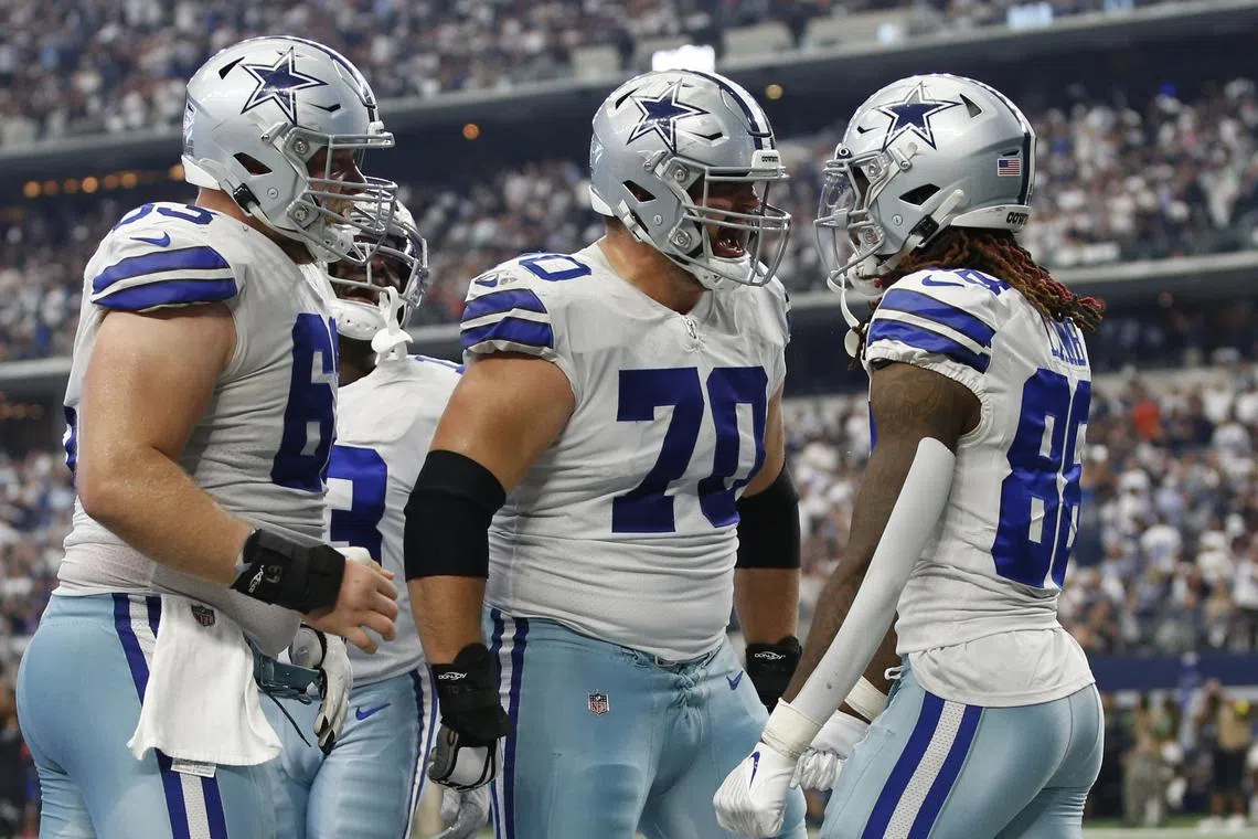 Oct 2, 2022; Arlington, Texas, USA; Dallas Cowboys center Tyler Biadasz (63) and guard Zack Martin (70) and wide receiver CeeDee Lamb (88) celebrate a touchdown in the fourth quarter against the Washington Commanders at AT&T Stadium. Mandatory Credit: Tim Heitman-USA TODAY Sports/ File Photo