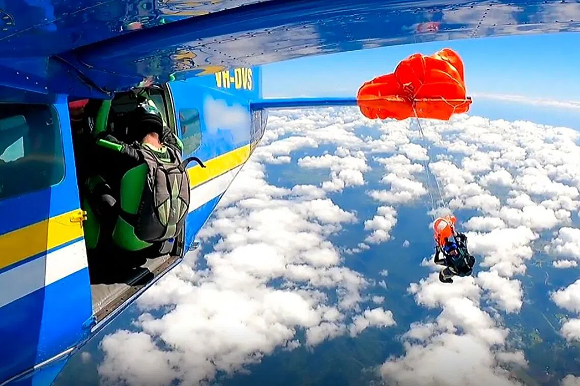 A screengrab image taken from undated video footage shows the moment a skydiver was left dangling thousands of metres in the air after their parachute caught on the plane's tail.