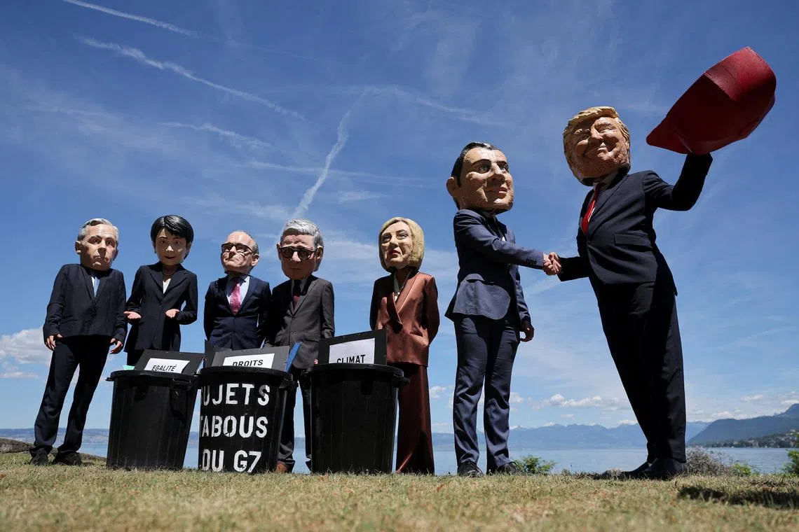 Oxfam activists wearing doll heads depicting G7 leaders, performing during a protest against the upcoming G7 summit, in Publier near Evian, France, on June 14, 2026. 