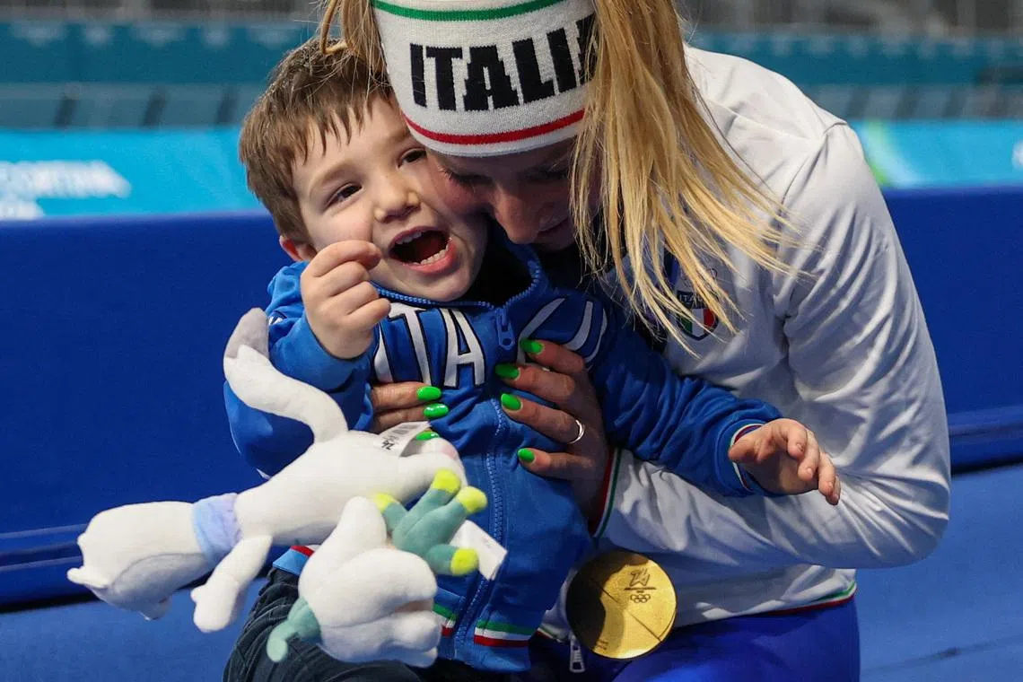 Gold medallist Francesca Lollobrigida of Italy celebrates her victory in the women's 3000m speed skating event with her son Tommaso in Milan, Italy, February 7, 2026. REUTERS/Piroschka Van De Wouw