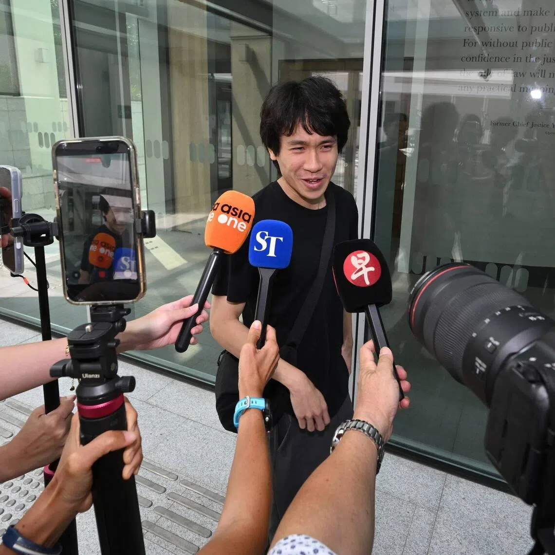 Amos Yee leaving the State Courts on Aug 26. He faces seven charges in total, including three under the Enlistment Act.