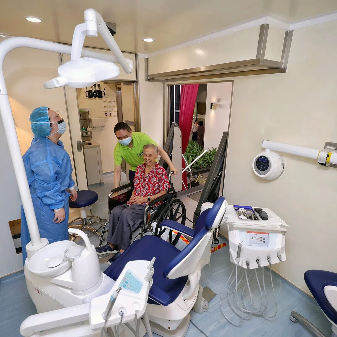 Madam Toh Yeow Leng being assisted up via a ramp and into the mobile dental clinic at Bright Hill Evergreen Home on Sept 26.