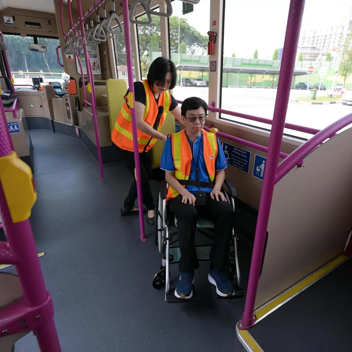 Kris Loy (R), 50, associate trainer with SBS Transit and SG Enable demonstrates how a wheelchair user could be helped into the bus. The demonstration was done at the official  opening of the new Public Transport Inclusivity Training Centre (PTITC) on April 10, 2026.