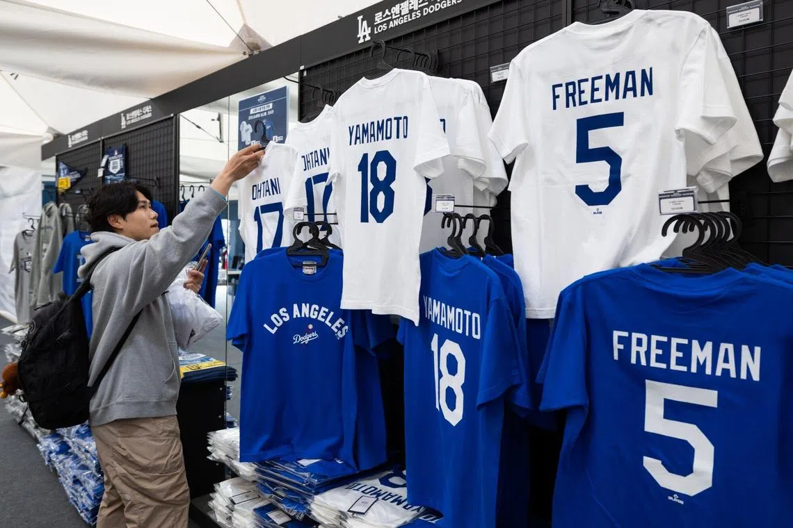 A fan looks at T-shirts of Shohei Ohtani, baseball player of the Los Angeles Dodgers, at the MLB Superstore outside the Gocheok Sky Dome in Seoul.