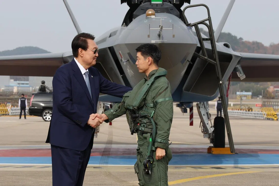 South Korean President Yoon Suk-yeok (L) meets an Air Force pilot who conducts test flights of South Korea's homegrown fighter jet, at the Korea Aerospace Industries (KAI) in Sacheon.