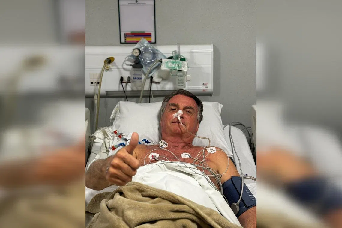 Former Brazilian president Jair Bolsonaro gesturing from a hospital bed in Natal, Brazil, on April 12.
