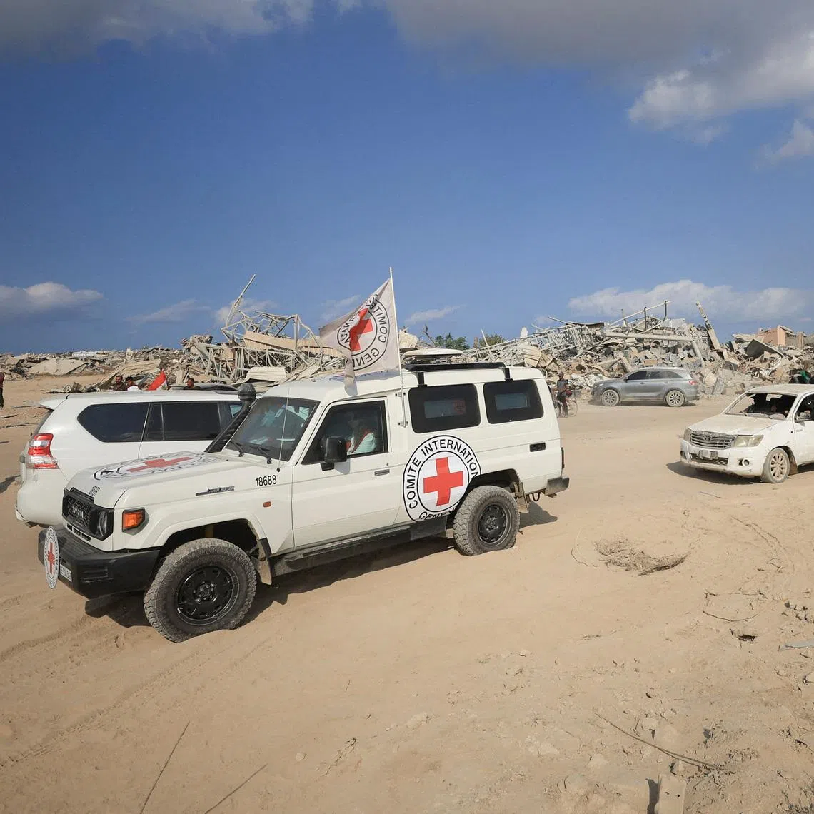 FILE PHOTO: Red Cross personnel, escorted by Hamas militants, wait to head towards an area within the so-called \"yellow line\" to which Israeli troops withdrew under the ceasefire, as Hamas says it continues to search for the bodies of deceased hostages seized during the October 7, 2023, attack on Israel, in Gaza City November 12, 2025. REUTERS/Dawoud Abu Alkas/File Photo