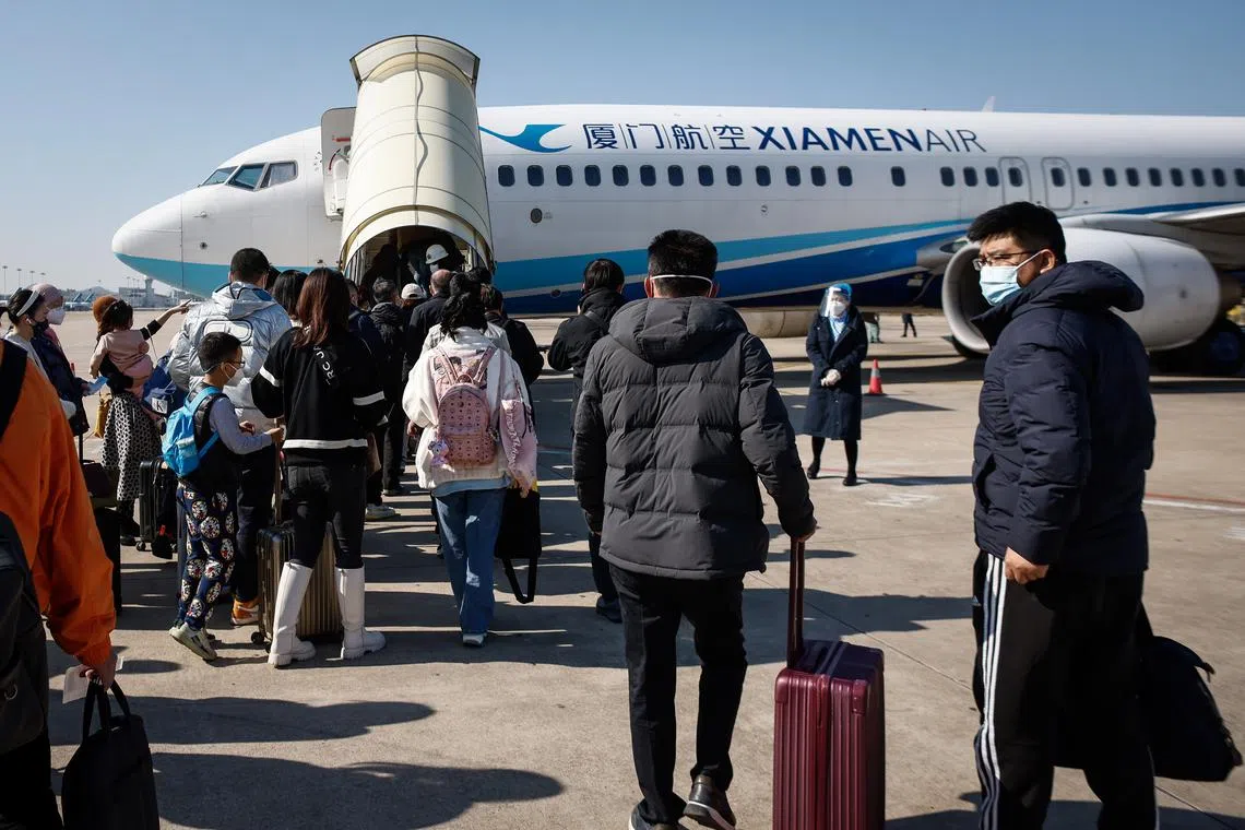 Passengers bound for Beijing board an airplane at the Xiamen Gaoqi International Airport in Fujian province on Dec 26, 2022.