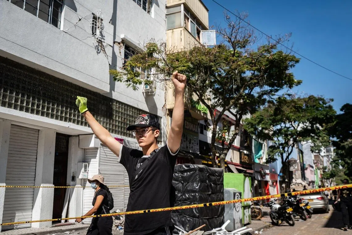 A volunteer signals for silence to listen for sounds of survivors.