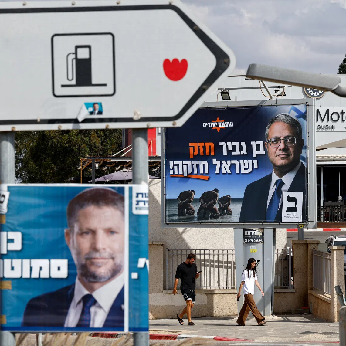 People walk near election banners with images of Israel's National Security Minister Itamar Ben-Gvir, leader of the Jewish Power (Otzma Yehudit) party, and Finance Minister Bezalel Smotrich, leader of the Religious Zionist Party, in Sderot, near Israel's border with Gaza, in southern Israel, October 18, 2026. REUTERS/Amir Cohen     TPX IMAGES OF THE DAY