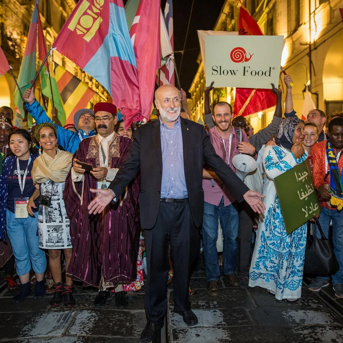 Carlo Petrini, founder of the Italian ‘Slow Food’ movement that promotes quality food, genuine ingredients and local produce, walks with participants during a Slow Food gathering in this undated handout picture. SLOW FOOD/Handout via REUTERS