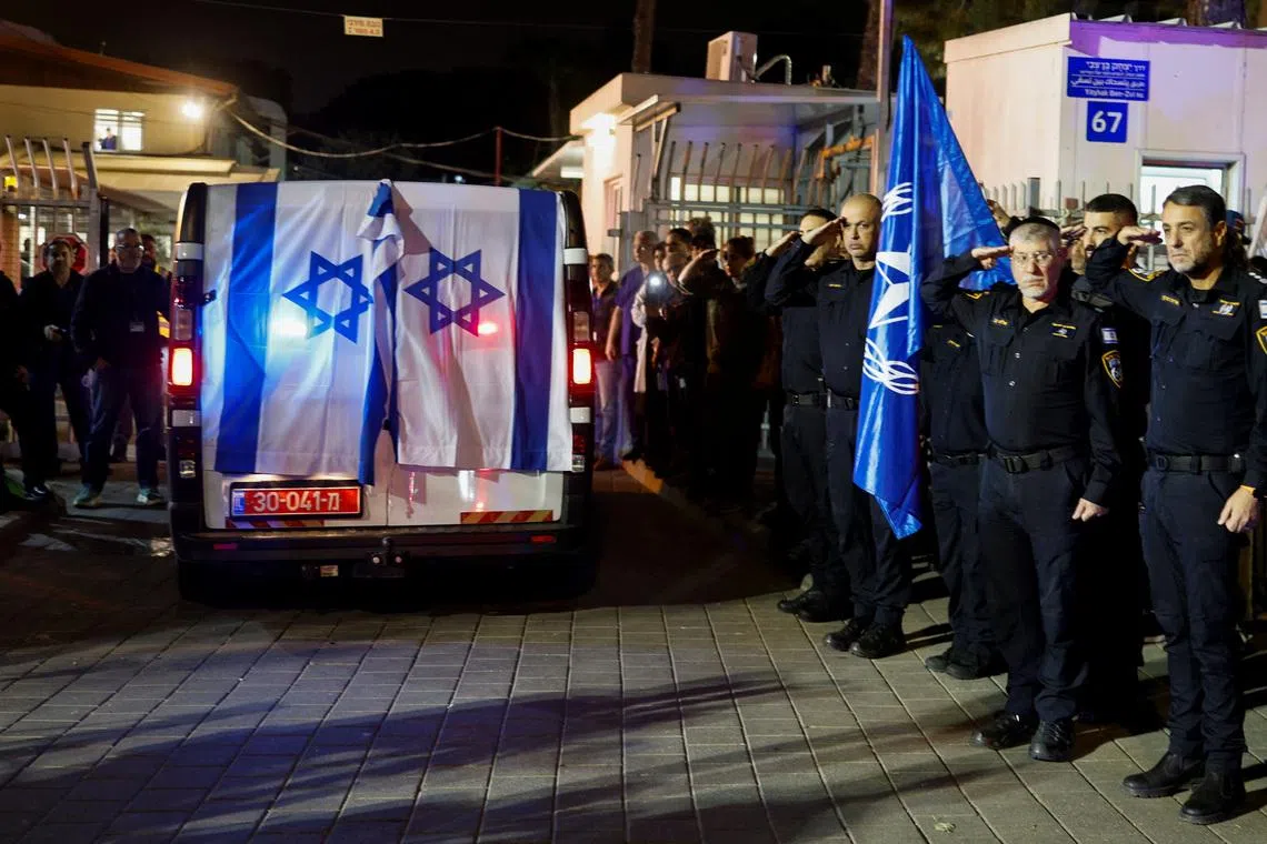 Police officers salute as the vehicle carrying the body of Israeli police officer, and the last hostage Ran Gvili, kidnapped in the October 7, 2023, Hamas attack, arrives to the Institute of Forensic Medicine after being found and identified in the Gaza Strip, according to the statement by the Israeli military, in Tel Aviv, Israel, January 26, 2026. REUTERS/Amir Cohen