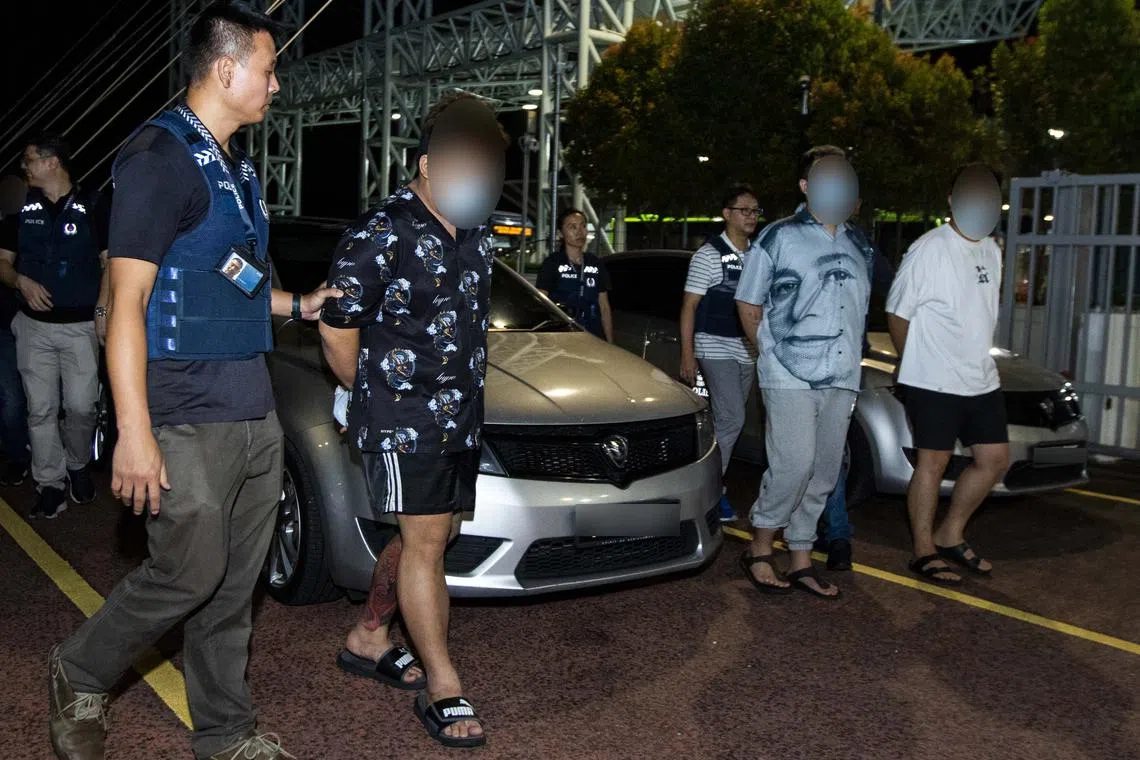 Suspects being extradited to Singapore, following a joint raid by Malaysian and Singaporean authorities in Johor.
