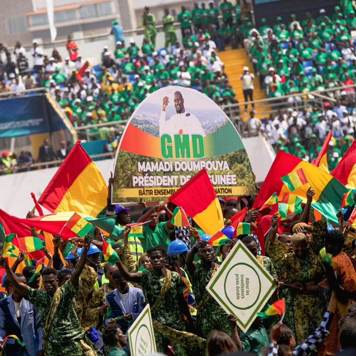 Supporters of Guinea's President-elect Mamady Doumbouya hold Guinean flags during his swearing-in ceremony in Conakry, Guinea, January 17, 2026. REUTERS/Souleymane Camara