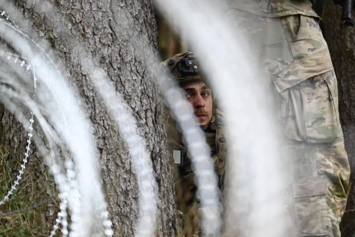 A US soldier is seen behind barbed wire during the NATO exercise 'Saber Junction 23' at the training area in southern Germany, on Sept 14.