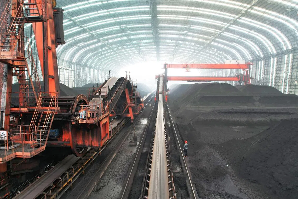 Coal is seen in a storage facility at the Jiangsu Xinhai Power Generation Co., Ltd in Lianyungang, in China’s eastern Jiangsu province on July 14, 2023. The company stores enough coal for 10 days of electricity production at the plant. (Photo by STRINGER / AFP) / China OUT