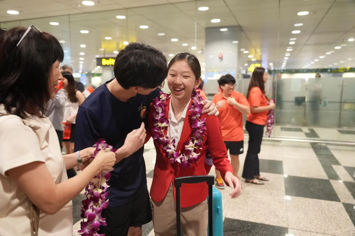 National swimmer Julia Yeo, 14, being welcomed by her family after returning from the Thailand SEA Games on Dec 16, 2025. Yeo won gold for Singapore, alongside teammates Quah Ting Wen, Quah Jing Wen and Letitia Sim.