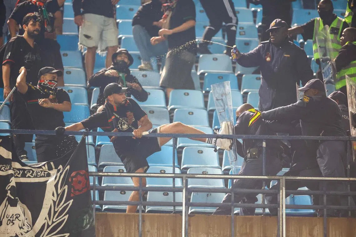 Royal Armed Forces supporters clash with South African Police Service officers in the stands during the CAF Champions League final first leg football match against Mamelodi Sundowns at Loftus Versfeld Stadium in Pretoria on May 17, 2026.