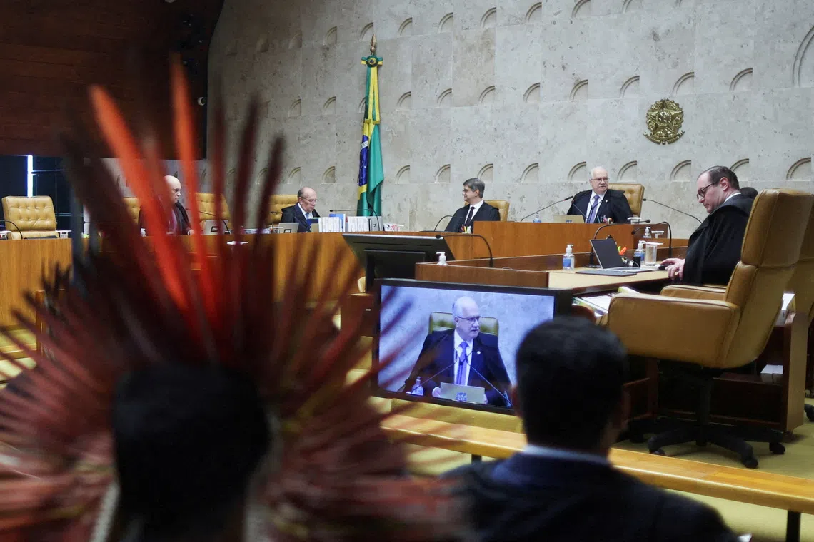 FILE PHOTO: An Indigenous person sits while attending a session where judges discuss the so-called legal thesis of \"Marco Temporal\" (Temporal Milestone) and land demarcation, at the Supreme Court in Brasilia, Brazil, December 10, 2025. REUTERS/Adriano Machado/File Photo