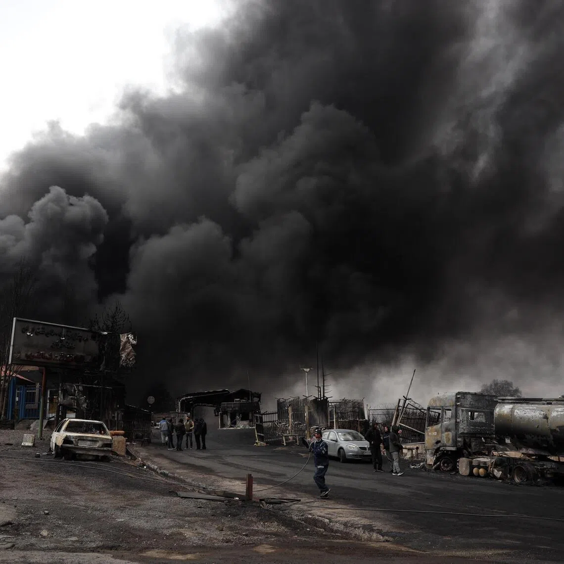 A view of the main gate to the Shahran Oil Refinery as smoke still rises following last night airstrike in Tehran, Iran, on March 8.