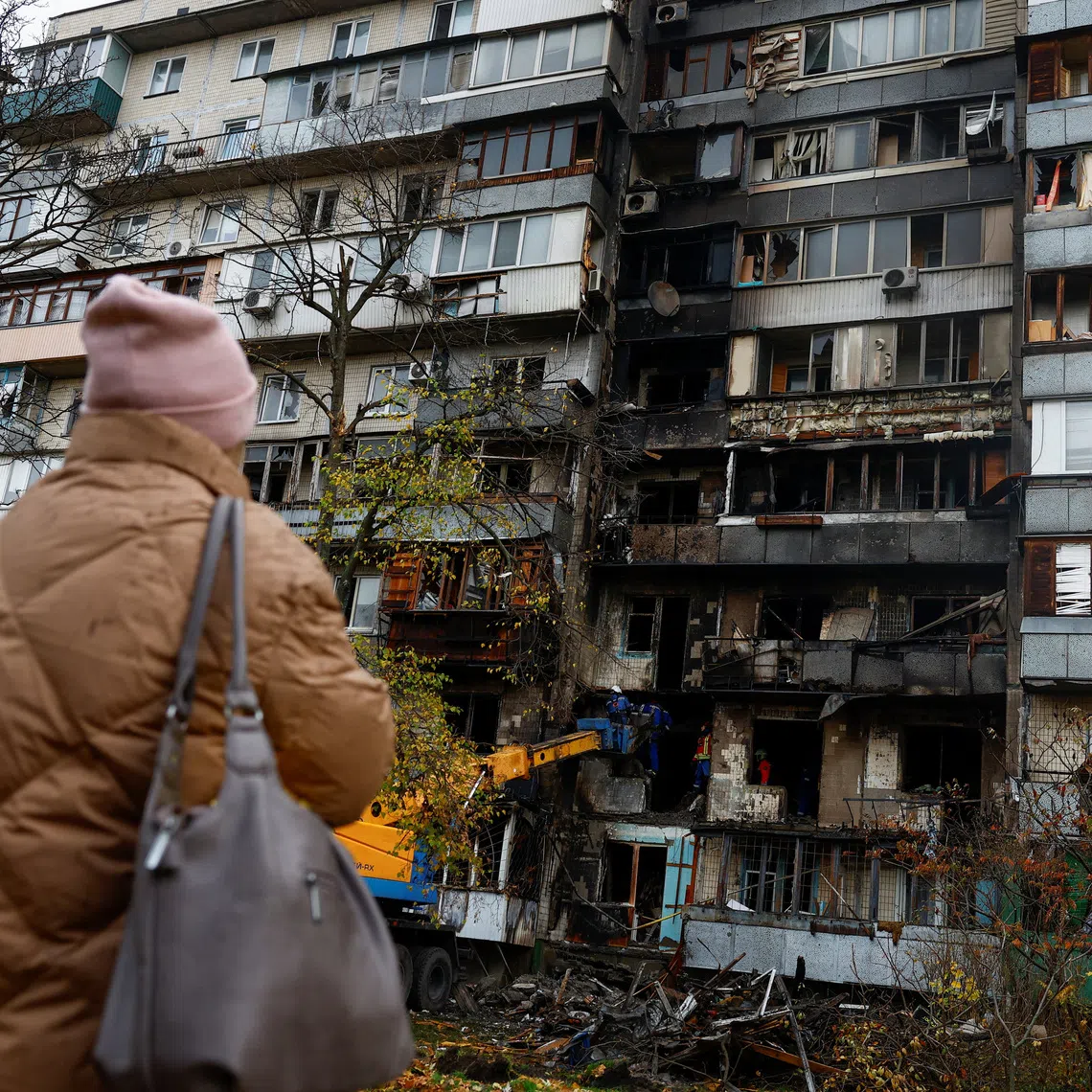 An emergency service psychologist speaks to a resident while she looks at her apartment building which was damaged during an overnight Russian drone strike, amid Russia's attack on Ukraine, in Kyiv, Ukraine October 26, 2025. REUTERS/Valentyn Ogirenko