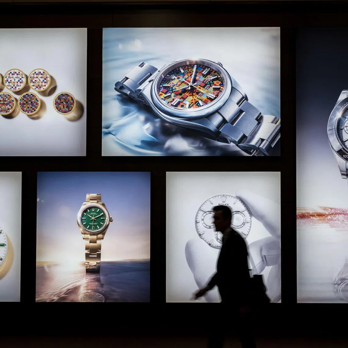 A visitor walks past photographs at the stand of Swiss luxury watchmaker Rolex during the opening day of the "Watches and Wonders Geneva" luxury watch fair, in Geneva, on April 14.