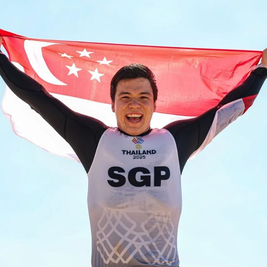 Max Maeder holding the Singapore flag high after winning kitefoiling gold in Chonburi on Dec 16.