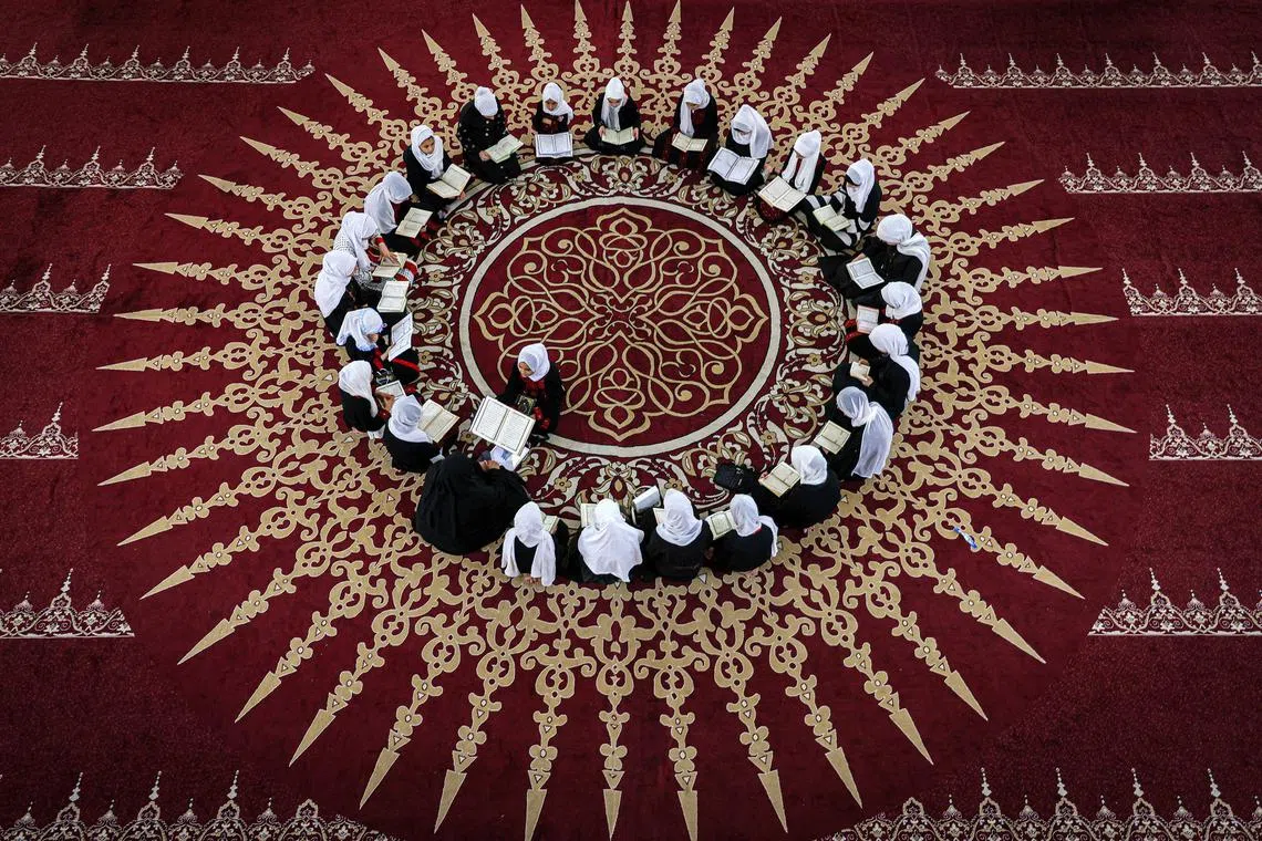 Palestinian Muslim girls sitting together in a circle at a class for the recitation of the Koran, Islam's holy book, during a summer camp at a mosque in Gaza city on June 13, 2023. 