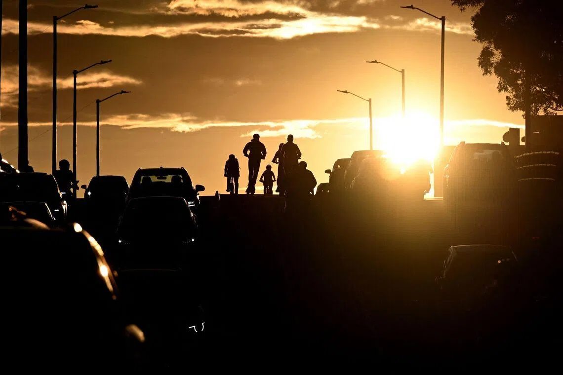 Cyclists riding past a traffic jam during sunset in Bogota, Colombia, on April 20, 2026.