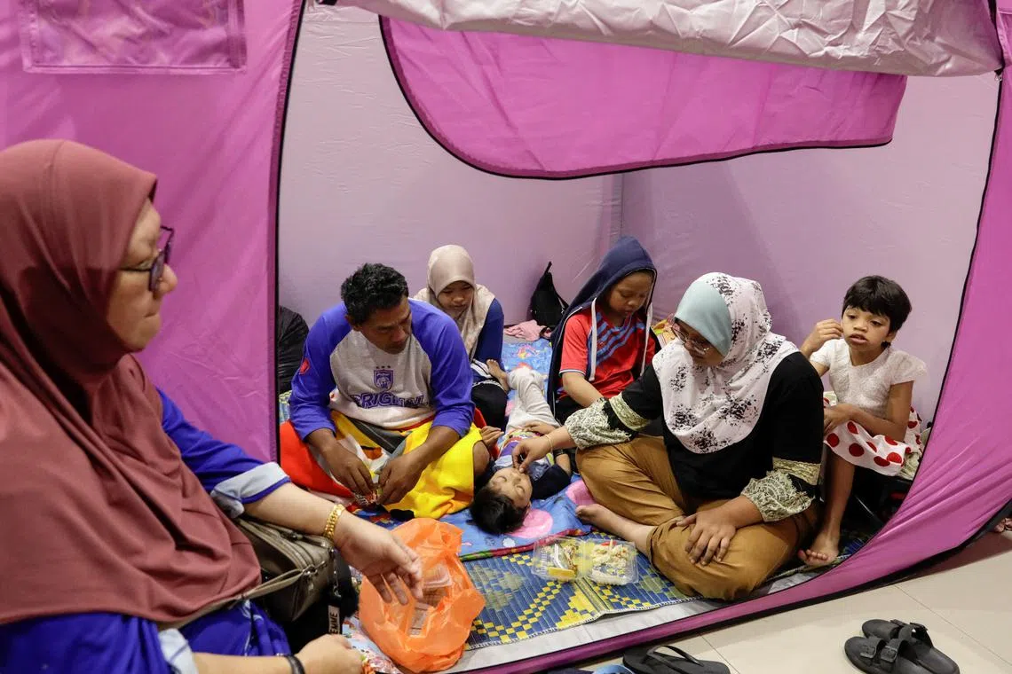 A family of flood victims rest inside a tent at an evacuation centre after their house was submerged in floodwaters at Kota Tinggi, Johor, Malaysia, March 5, 2023. 