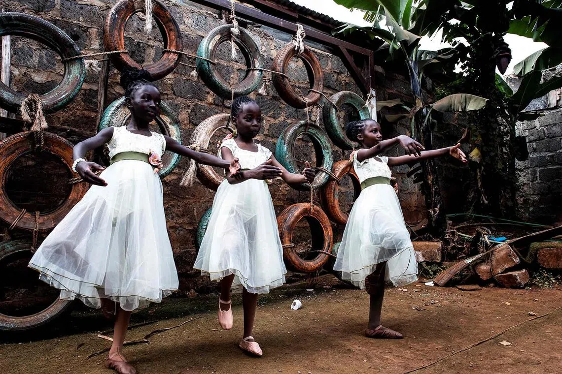 TOPSHOT - Ballet students from the Kibera based Project Elimu warm up ahead of a public show in Kibera on August 14, 2024. Project Elimu, a community driven non profit organization, provides afterschool art, sport education programs for young people age 3 to 22. During school holidays the center holds street perfomances to encourage more students to join the dance center. Kibera is the largest slum in Nairobi, one of the largest in Africa. (Photo by Gordwin ODHIAMBO / AFP)
