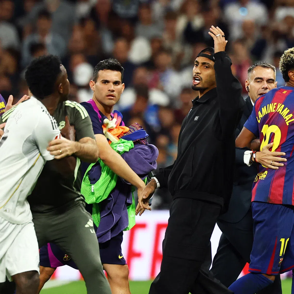 Soccer Football - LaLiga - Real Madrid v FC Barcelona - Santiago Bernabeu, Madrid, Spain - October 26, 2025 FC Barcelona's Lamine Yamal and Real Madrid's Vinicius Junior clash after the match REUTERS/Susana Vera