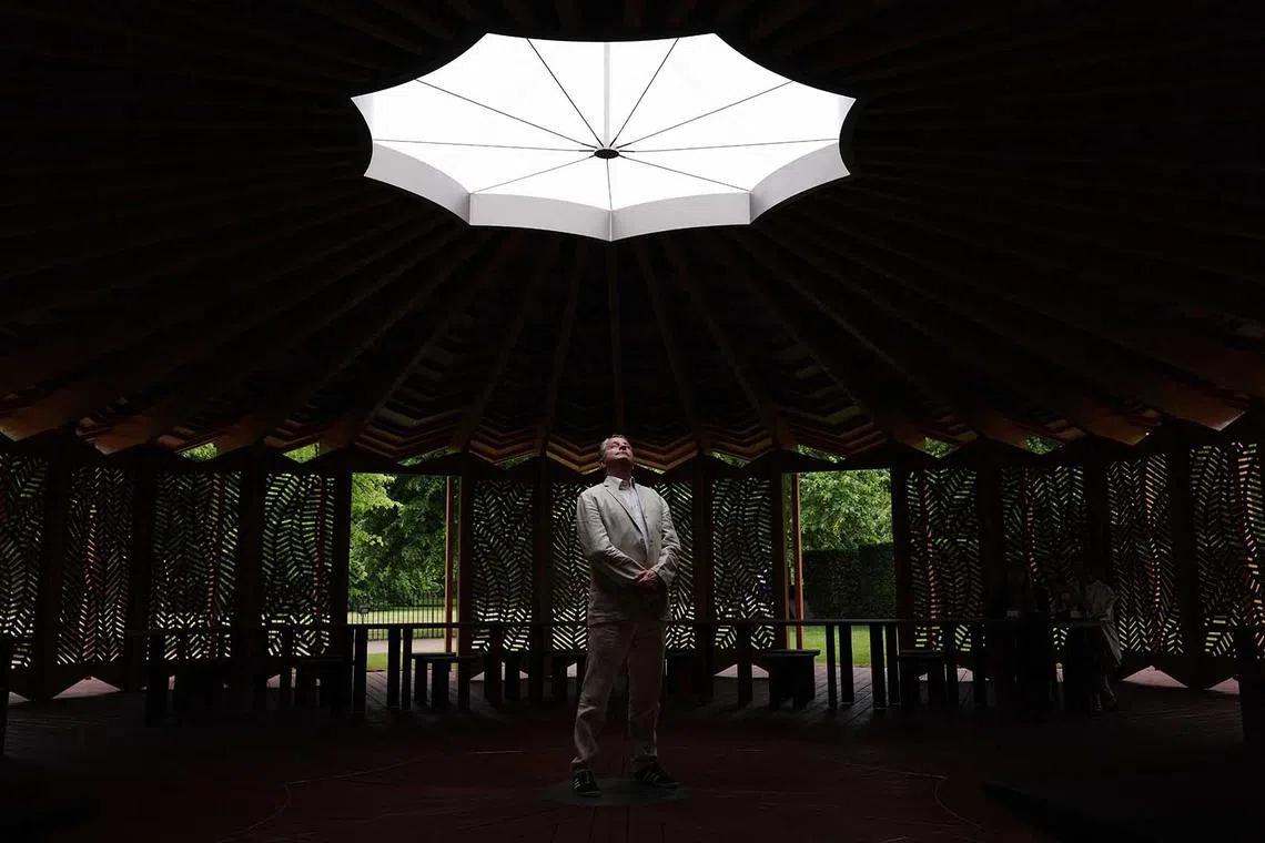 A visitor admires the roof of The Serpentine Pavilion, designed by French-Lebanese architect Lina Ghotmeh, at Serpentine South in Kensington Gardens in central London on June 5.