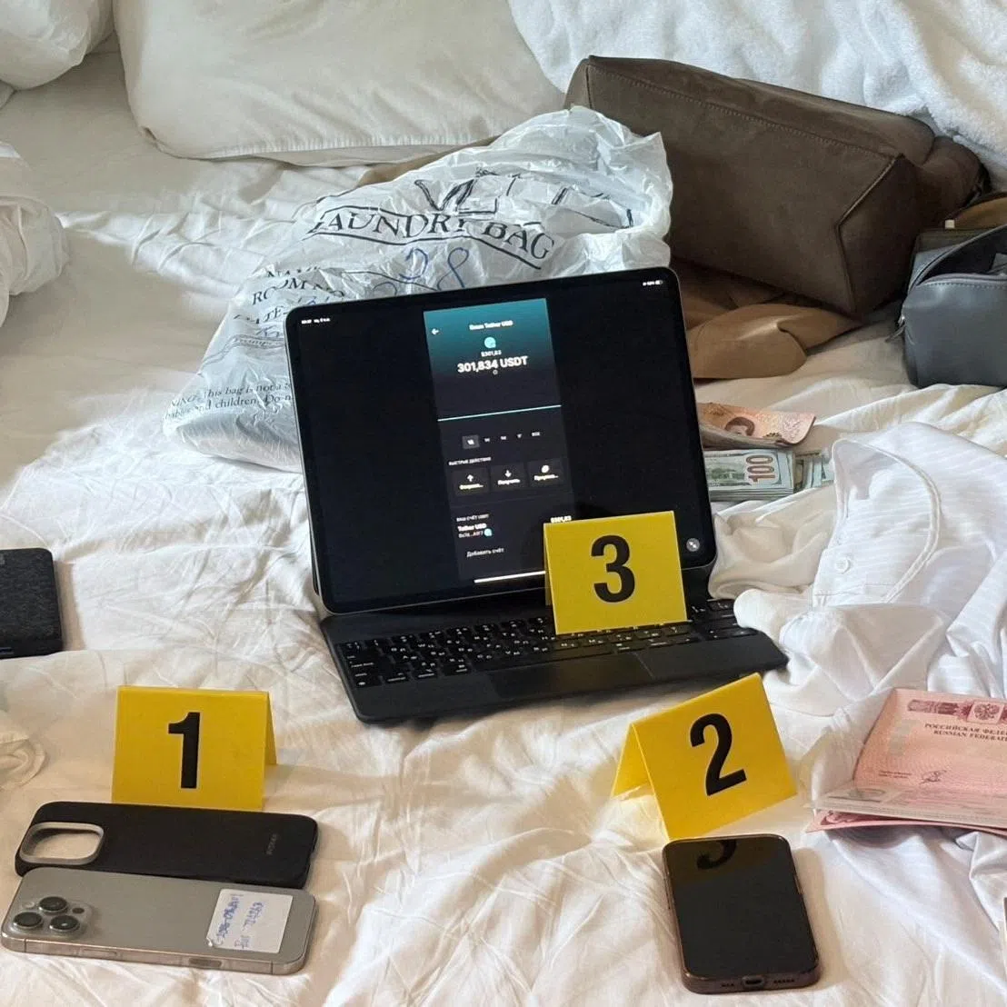 Evidence related to a Russian man, Denis Obrezko, lies on a bed in Phuket, Thailand, November 12, 2025. U.S. prosecutors say Denis Obrezko previously worked for Russia's FSB intelligence agency. Thailand's Cyber Crime Investigation Bureau/Handout via REUTERS