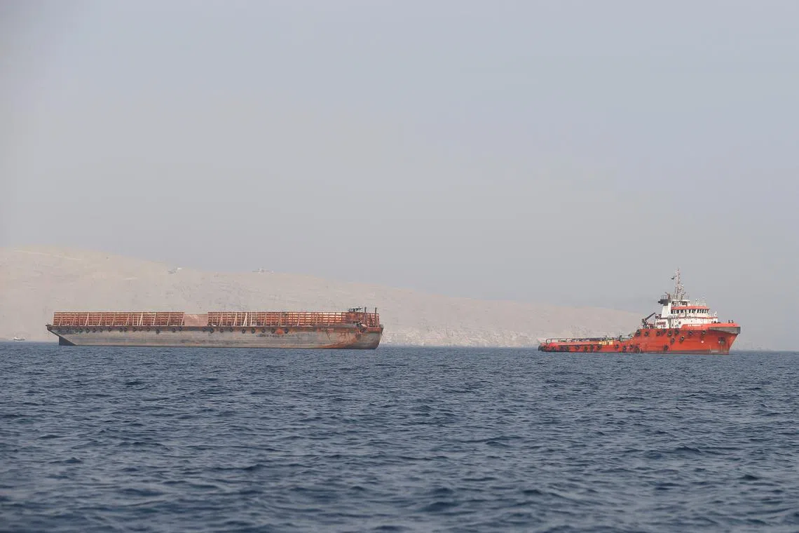 FILE PHOTO: A tug boat moves cargo towards the Strait of Hormuz, in Musandam province, Oman, July 20, 2018. Picture taken on July 20, 2018. REUTERS/Hamad I Mohammed/ File Photo