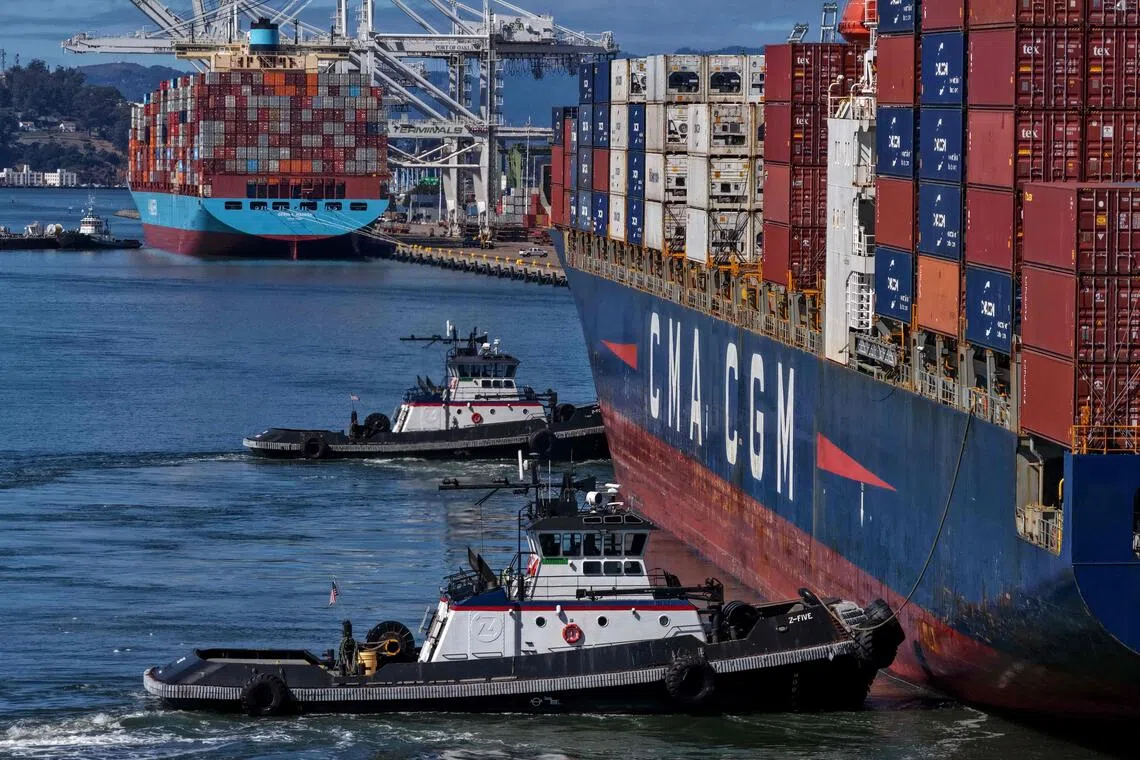 OAKLAND, CALIFORNIA - OCTOBER 10: In an aerial view, tugboats assist a container ship as it arrives at the Port of Oakland on October 10, 2025 in Oakland, California. U.S. President Donald Trump is threatening to impose a massive increase of tariffs on Chinese imports in response to China's announcement of new export controls on rare earths. China controls an estimated 70% of the global supply of rare earths minerals.   Justin Sullivan/Getty Images/AFP (Photo by JUSTIN SULLIVAN / GETTY IMAGES NORTH AMERICA / Getty Images via AFP)