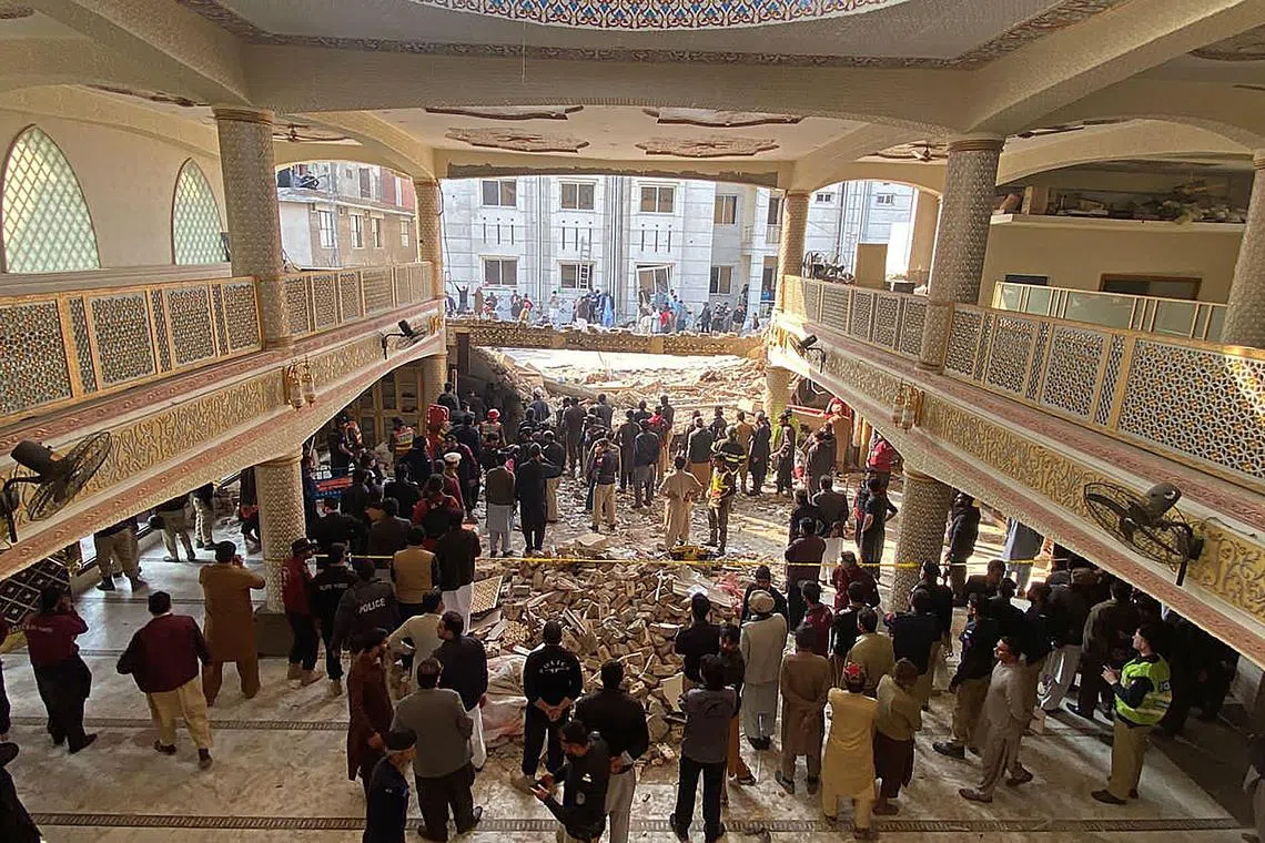 Security officials inspect the site of a mosque blast inside the police headquarters in Peshawar on Jan 30, 2023. -At least 17 people were killed in a mosque blast at a police headquarters in Pakistan, a hospital official said. 