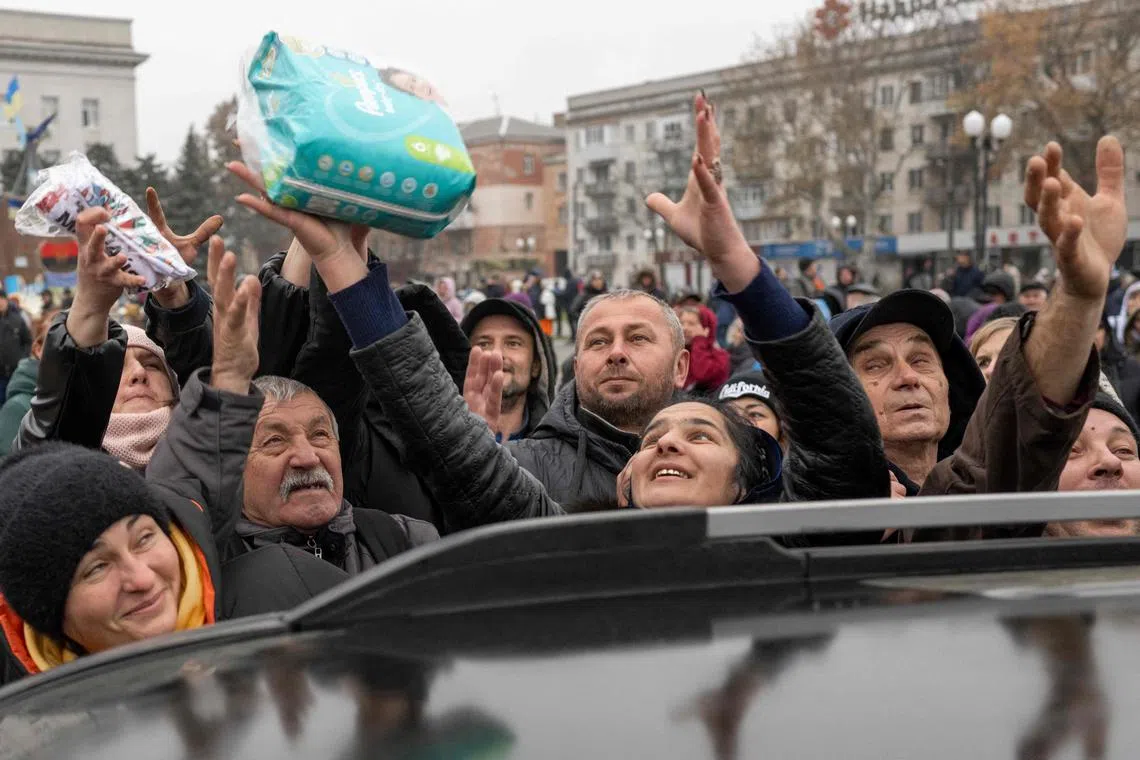 Residents waiting to get items from an aid supply distribution point in Kherson, on Nov 17, 2022.