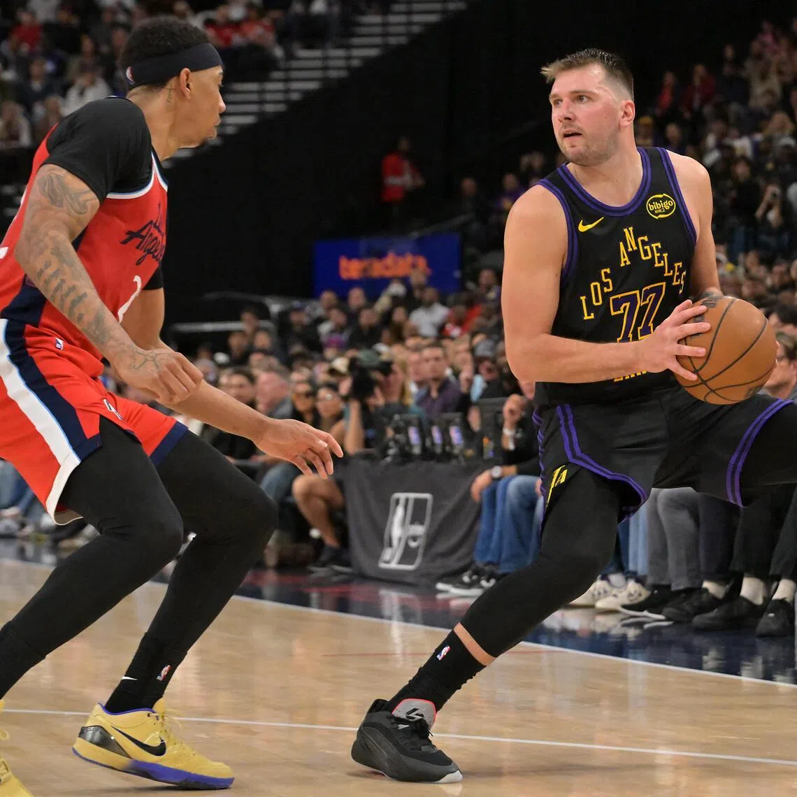 Los Angeles Lakers guard Luka Doncic (No. 77) being defended by Jordan Miller (in red) of the Los Angeles Clippers during the second half of the Clippers' 112-104 NBA win at Intuit Dome on Jan 22.