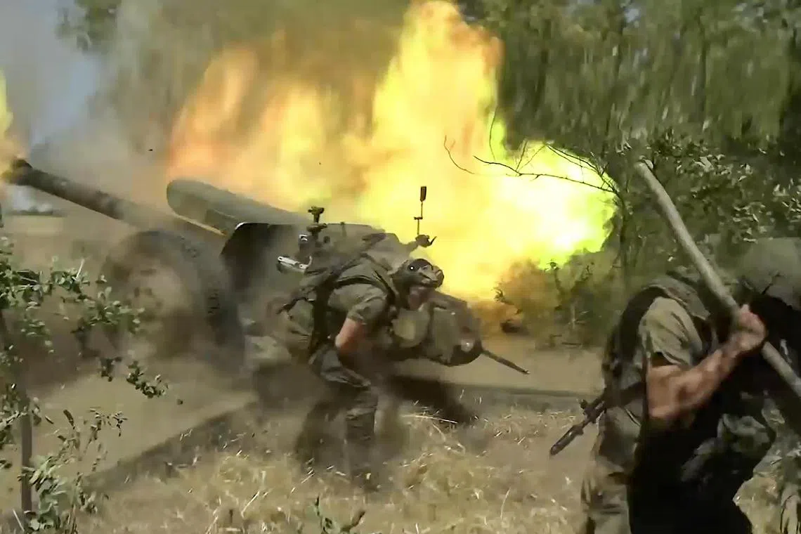 Russian soldiers fire a 122mm howitzer towards Ukrainian positions at an undisclosed location.