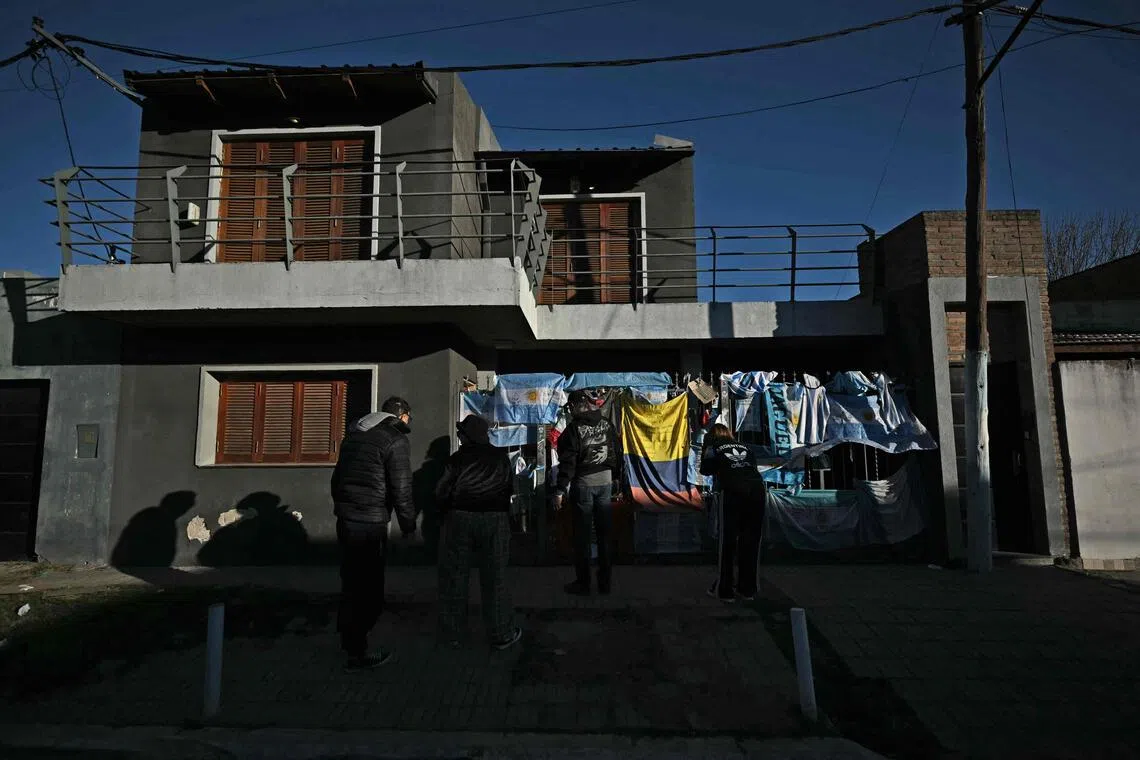 People leaving flags and signs to pay respects on the fence of Argentina’s football star Lionel Messi’s birth house in Rosario, Santa Fe province, Argentina, on August 8, after his father, Jorge Messi, died.