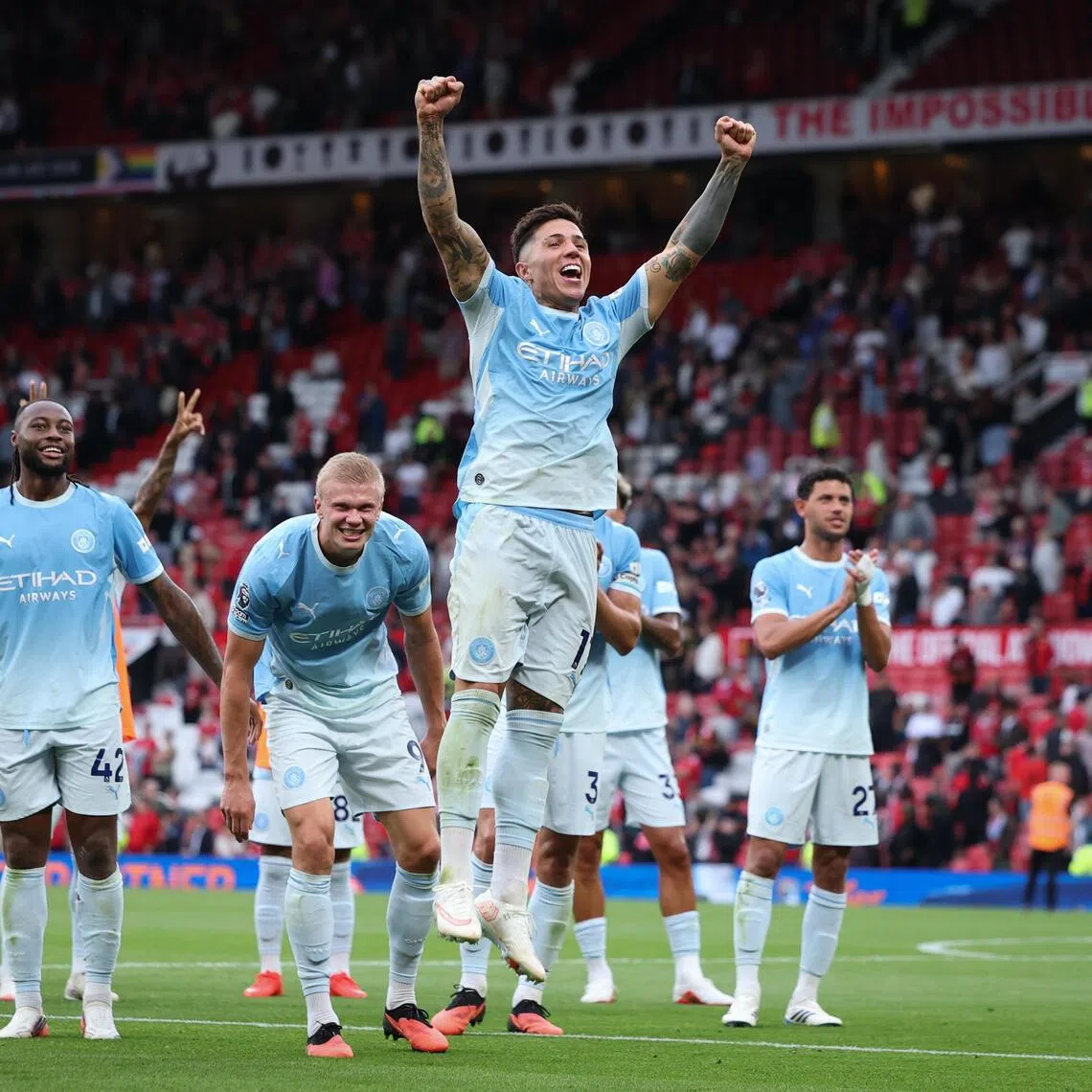 Enzo Fernandez of Manchester City and teammates cheer with supporters after their 1-0 Premier League win over Manchester United.
