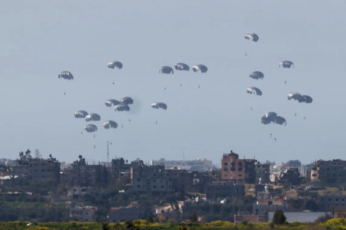 Packages fall towards Gaza, after being dropped from a military aircraft, amid the ongoing conflict between Israel and the Palestinian group Hamas, as seen from Israel's border with Gaza in southern Israel March 5, 2024. REUTERS/Amir Cohen