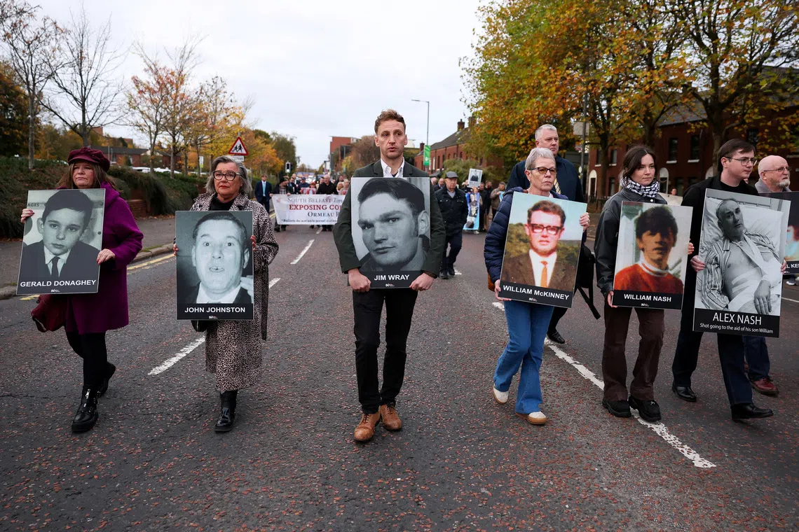 Family members hold pictures of victims of the 1972 'Bloody Sunday', as a judge is expected to give a verdict on the trial of the British army veteran known as 'Soldier F', charged with two murders and five attempted murders in relation to Bloody Sunday, in Belfast, Northern Ireland, October 23, 2025. REUTERS/Cathal McNaughton