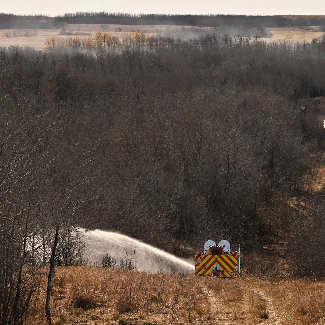 Firefighters continue to work on hot spots, the day after a serious incident that resulted in a fire caused deaths and injuries, in Wainwright, Alberta, Canada, October 18, 2026. REUTERS/Jennifer Gauthier