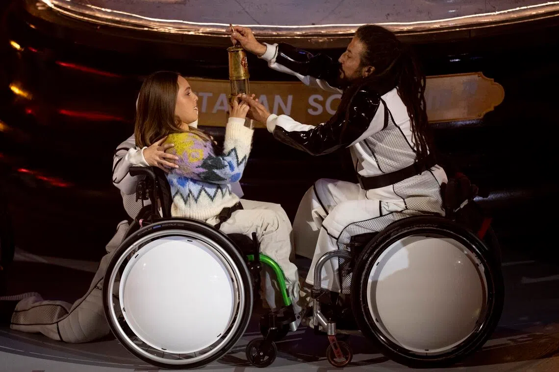 Performers extinguishing the Paralympic flame during the closing ceremony of the 2026 Milano-Cortina Paralympic Winter Games in Cortina d'Ampezzo on March 15, 2026.