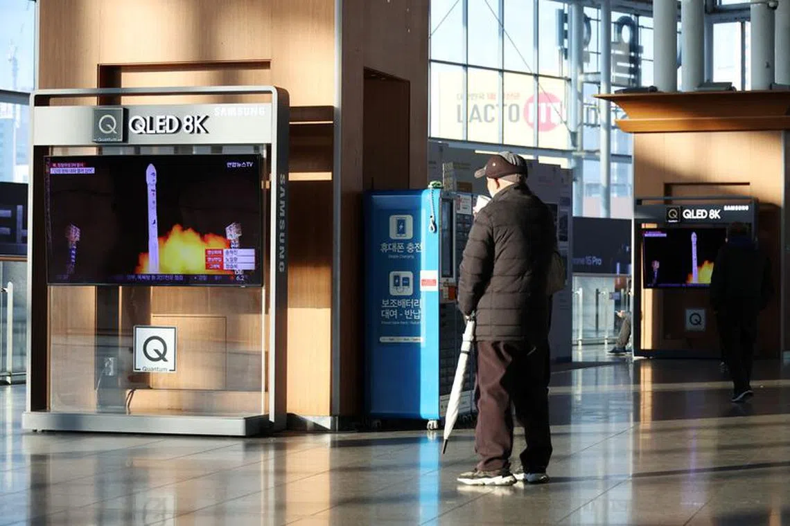 A man watches a TV broadcasting a news report on North Korea launching a military satellite, at a railway station in Seoul, South Korea, November 22, 2023.   REUTERS/Kim Hong-Ji
