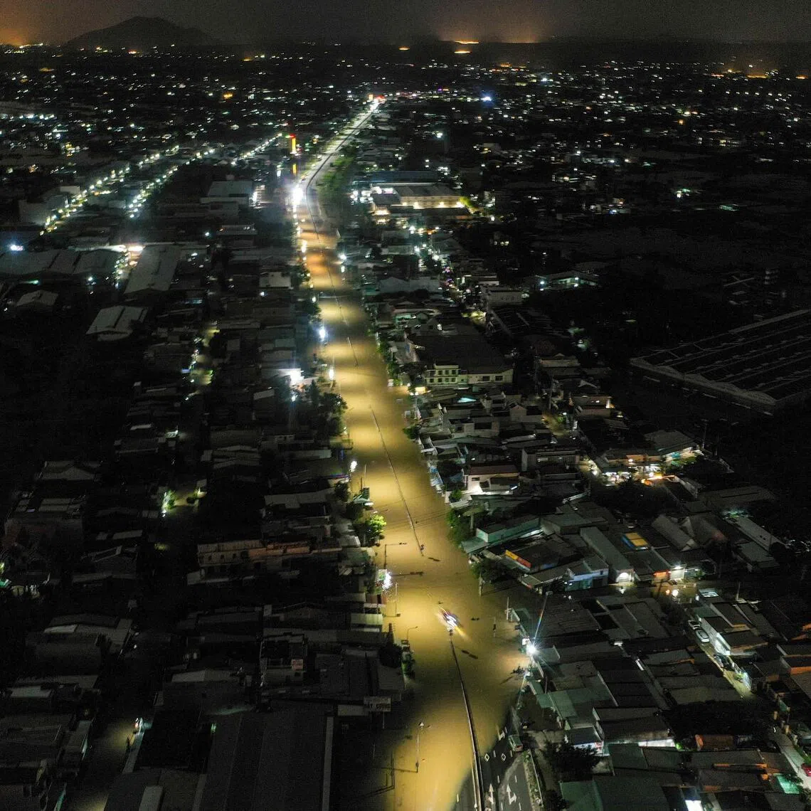 Water floods a road next to residential buildings in Vietnam's Lam Dong province on Dec 5, 2025, following weeks of heavy rain.