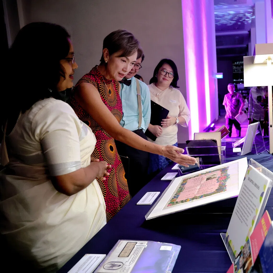 Minister for Digital Development and Information Josephine Teo viewing a marriage certificate of Mr Kok Yew Loong and Ms Wong Pui Wah from 1933.