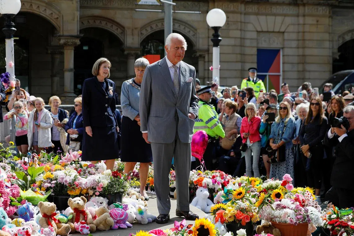 Britain's King Charles inspecting floral tributes outside Southport town hall, in memory of the knife attack victims. 